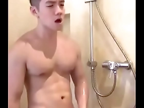 A handsome Asian man masturbates in the shower.